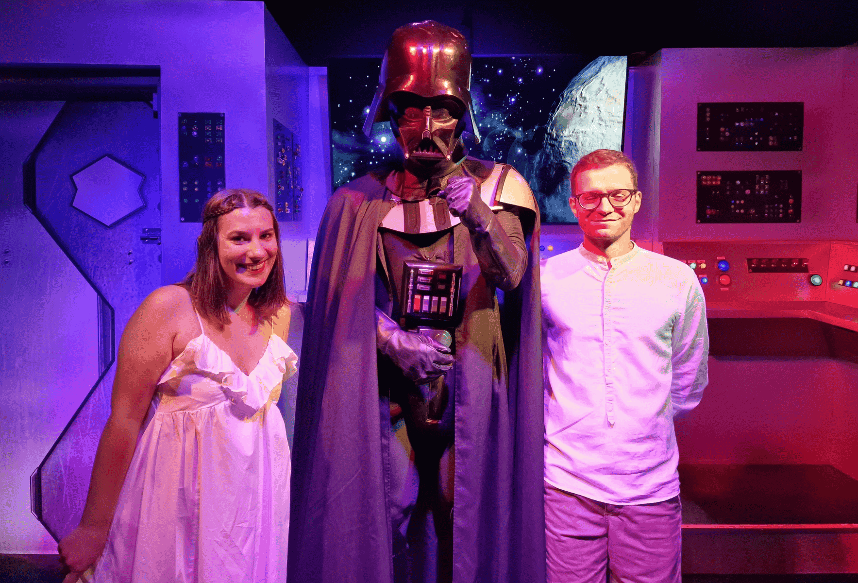 Alice Zilio travel designer sorridente in abito bianco e suo marito con una camicia chiara sono ai lati di Darth Veder che ha fatto da celebrante. Hanno appena celebrato il loro matrimonio a Las Vegas